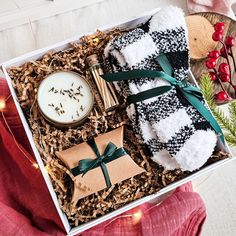 a gift box with candles, tea and cookies