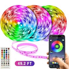 the colorful led strip is being held up by someone's hand with their cell phone