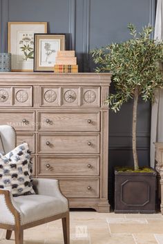 a white chair sitting in front of a wooden dresser