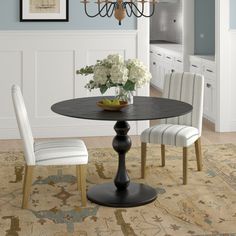 a dining room table with chairs and a chandelier hanging from the ceiling above it