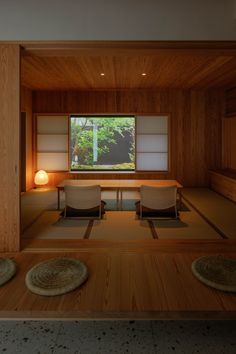 an empty room with two chairs and a table in front of a large screen window