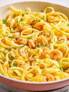 pasta with shrimp and parsley in a pink bowl