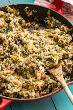 a pan filled with rice and vegetables on top of a blue table