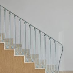 a cat sitting on top of a set of stairs next to a wall and carpeted floor