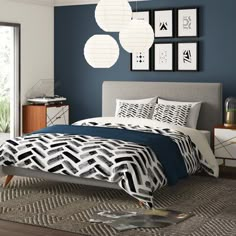 a bedroom with blue walls and white bedding in the corner, along with pictures on the wall