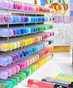 there are many markers and pens on the table next to each other in front of a calendar