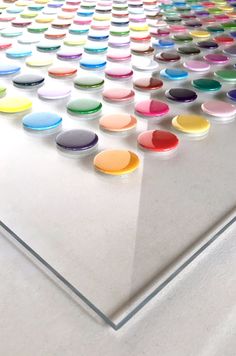 an array of different colored circles on a white surface with one circle in the middle