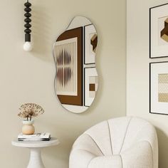 a white chair sitting next to a table with a vase and mirror on top of it