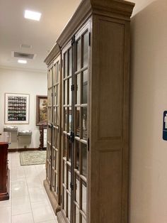 a wooden cabinet sitting in the middle of a hallway