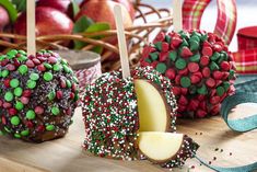 apples with sprinkles are on a wooden table next to other food items