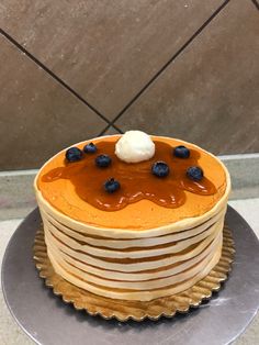 a stack of pancakes covered in chocolate and blueberries on top of a metal plate