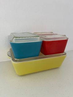 two plastic containers with lids sitting side by side on a white countertop next to each other