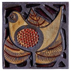 a decorative tile with a bird on it's back and an orange circle in the center