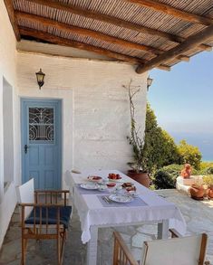 an outdoor dining area with table, chairs and door to the balcony overlooking the ocean