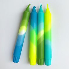 three different colored pens sitting next to each other