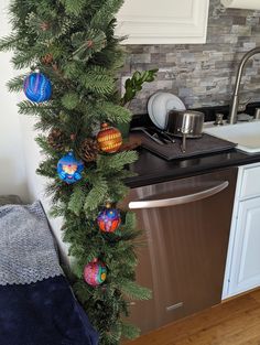 a kitchen with a dishwasher and christmas decorations on the counter top, next to a sink