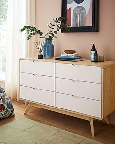 a white dresser with two vases on top of it