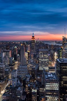 new york city skyline at night with the empire building in the foreground and other tall buildings