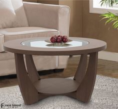 a glass table with two apples on it in front of a couch and coffee table