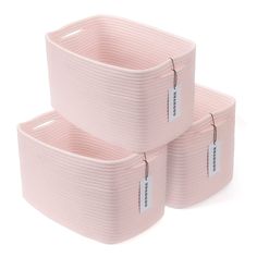 two pink storage baskets with tags on them sitting next to each other in front of a white background