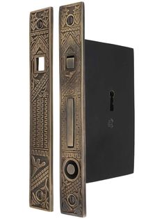 an ornate door handle and latch on a black wall mounted light switch cover with intricate designs