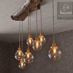 five light bulbs hanging from the ceiling in an old - fashioned style room with wood and stone walls