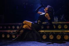 a woman in black dress sitting on stage