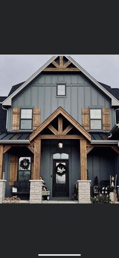 a large gray house with two story windows and a wreath hanging on the front door