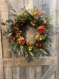 a wreath made out of flowers on top of a wooden door