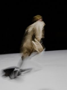 a blurry image of a man riding skis down a snow covered slope at night