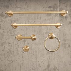 an assortment of brass handles and knobs on a concrete wall with a circular handle