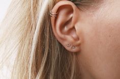 a close up of a woman's ear with two small piercings on it