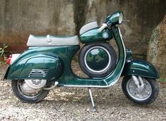 a green scooter parked in front of a wall