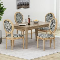 a dining room table with chairs and a bowl of fruit on the table next to it