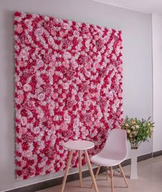 two white chairs are in front of a large pink flowered painting on the wall