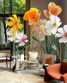 an arrangement of flowers in vases on display at a furniture showroom with chairs and tables