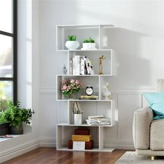 a living room with a couch, chair and bookshelf on the wall next to a window