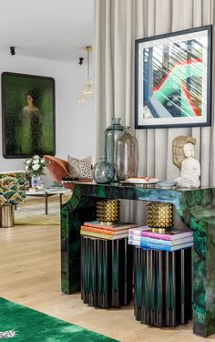 a living room filled with furniture and art on the wall next to a green rug