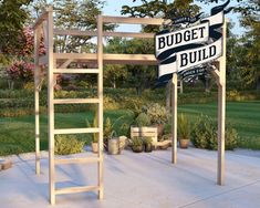 there is a sign that says budget build next to a ladder and potted plants