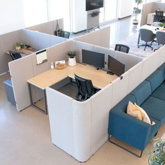 an office cubicle with couches and desks in the middle, along with chairs