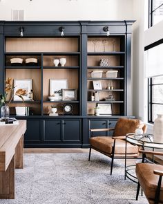 a living room filled with furniture and lots of shelves on top of each other in front of a window