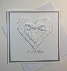 a white card with a heart and bow on it's side that says congratulations