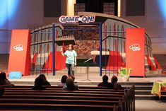 a woman standing on top of a stage in front of an audience at a game on