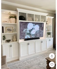 a flat screen tv sitting on top of a white entertainment center in a living room