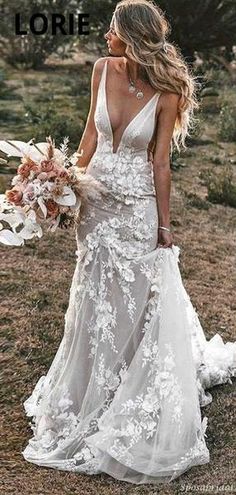 a woman in a white wedding dress with flowers on the side and her hair blowing in the wind