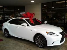 a white car with a red bow on the hood