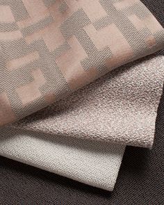 three different types of fabric on top of each other, one in grey and the other in beige