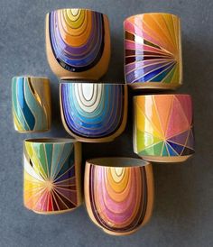 six colorful bowls sitting on top of a gray table next to each other and one has an upside down design