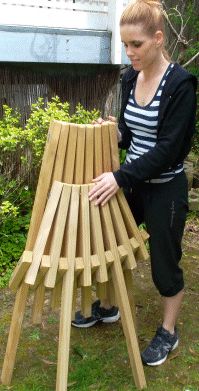 a woman kneeling down next to a bench made out of wooden planks in the grass