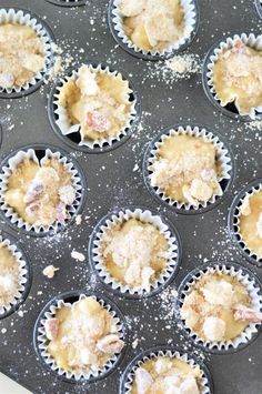 cupcakes with powdered sugar on top in muffin tins ready to go into the oven